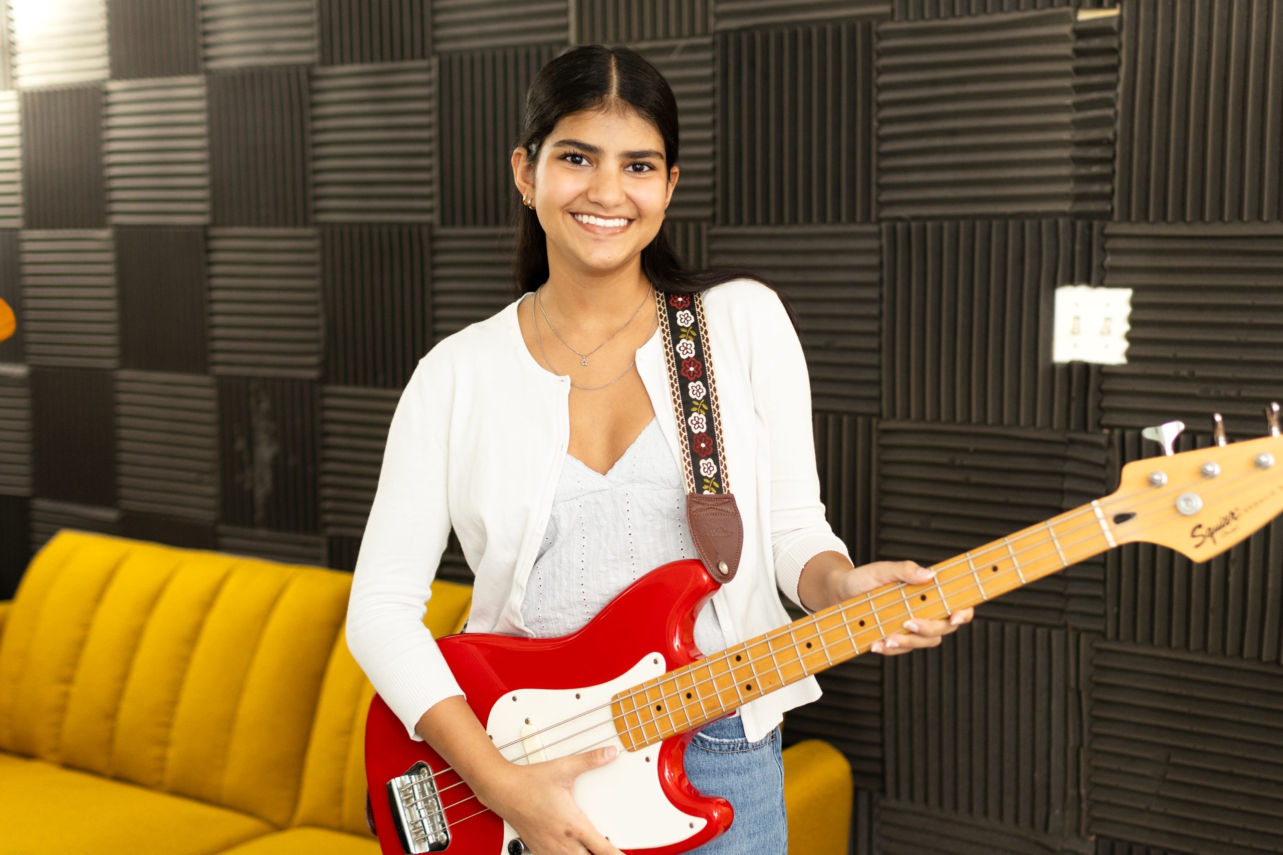 A bass student plays a red and white bass at Blue Frog School of music during one of their bass guitar lessons in South Austin
