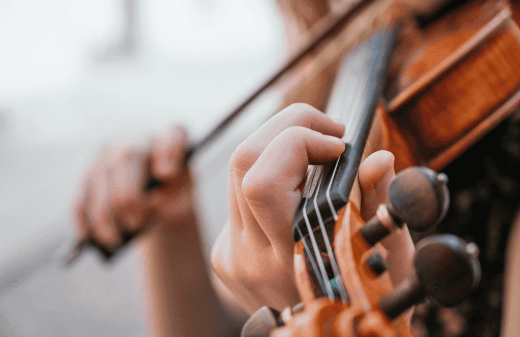 A close up shot of hands playing a violin at Blue Frog School of Music, home of high quality violin lessons in South Austin
